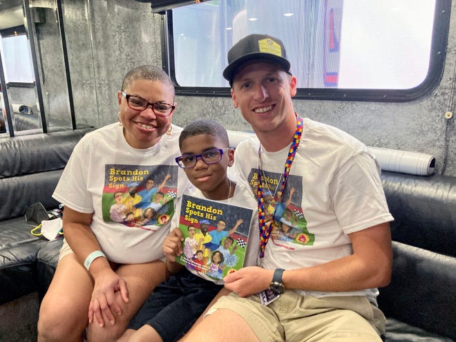 NASCAR driver Brandon Brown visits with Sheletta Brundidg, left, and her son Brandon on Saturday at Road America. Sheletta Brundidge wrote a children’s book in her son’s honor after Brandon Brundidge saw “Let’s go, Brandon” signs and assumed they were cheering him on.