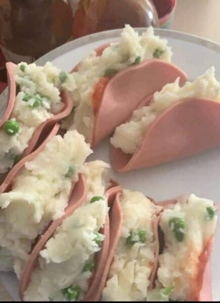 slices of bologna filled with mashed potatoes and peas
