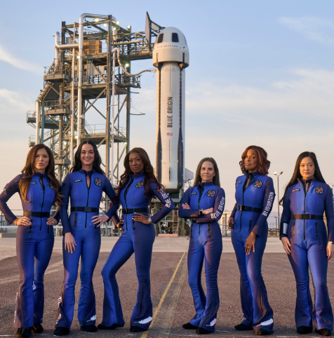 Blue Origin all-female crew posing in glamorous bell-bottomed space suits in front of crew leaders's boyfriend's privately owned rocket.