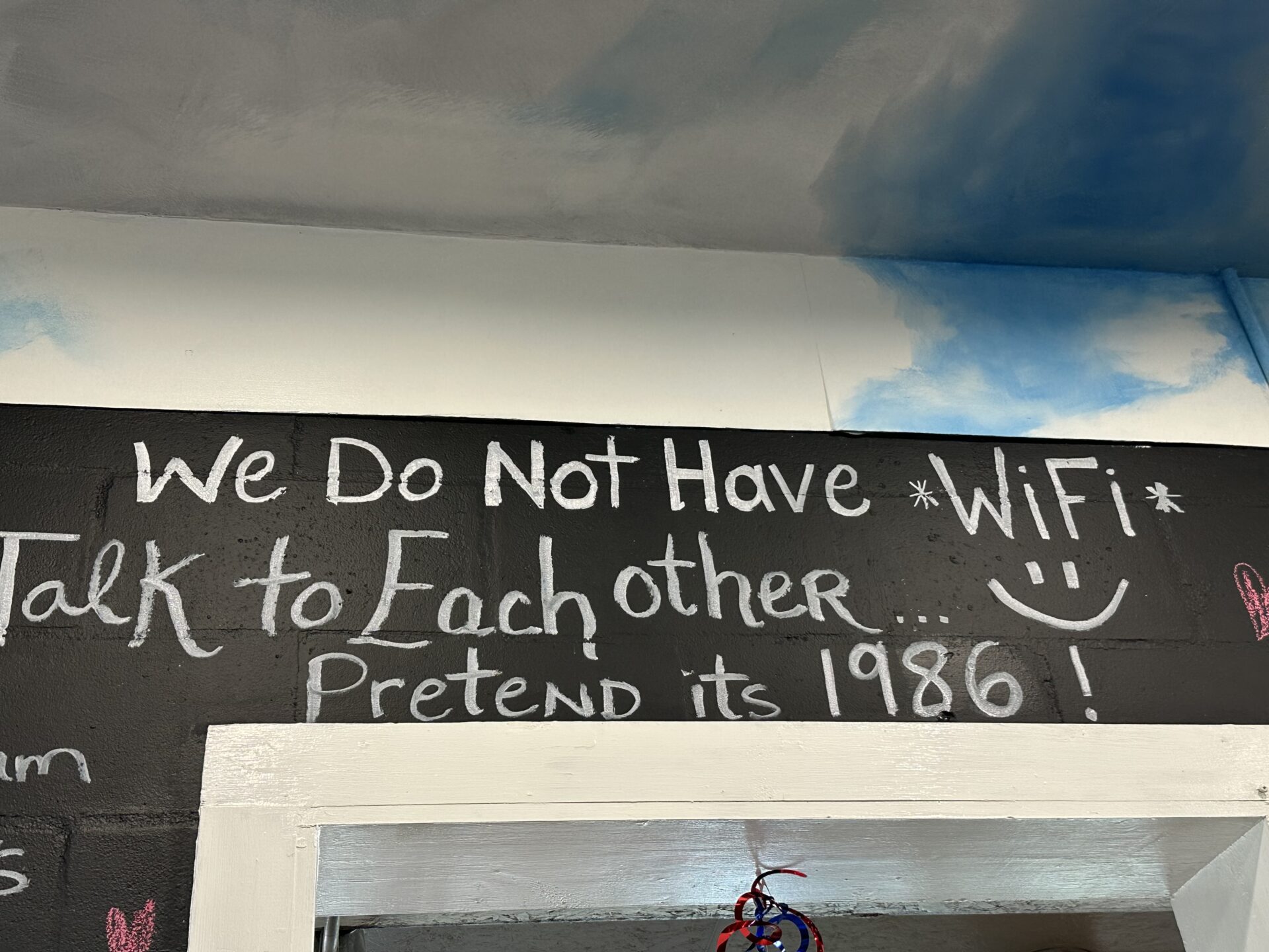 Sign that says, “We don’t have wi-fi. Talk to each other! Pretend it’s 1986.